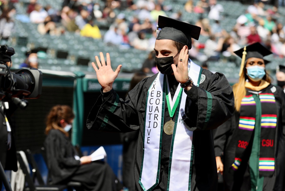 Student waving at Spring 2021 Commencement